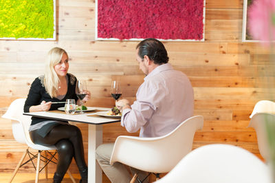 Mature couple having food and drink at restaurant