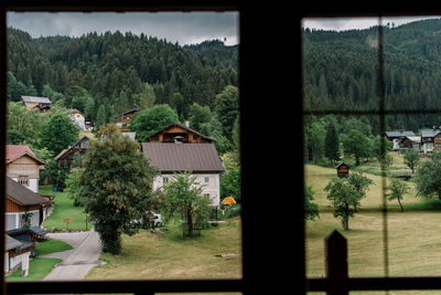 High angle view of trees and buildings seen through window