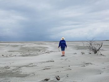 Rear view of man standing at beach