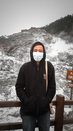 Portrait of young man standing in snow