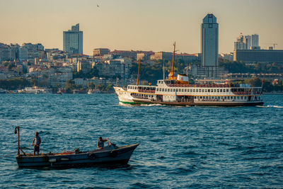 Boats sailing in sea against buildings