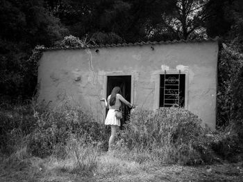 Rear view of woman standing by building