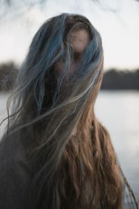 Close up long gray brown hair hiding woman face with wind portrait picture