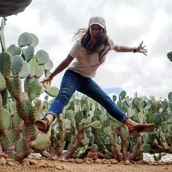 Low angle view of young woman in succulent plant against sky