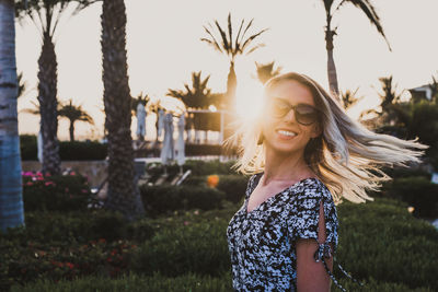 Portrait of young woman wearing sunglasses while standing outdoors