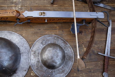 High angle view of medieval weapons on wooden table