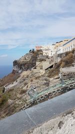 Scenic view of sea by buildings against sky