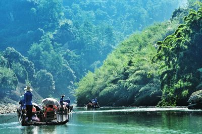 Rear view of people enjoying boat in sea