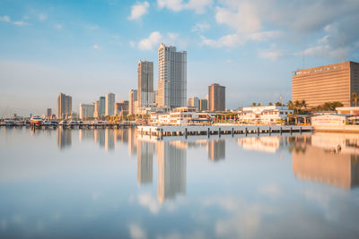 Reflection of buildings in city against sky