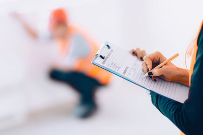 Cropped image of engineer writing in paper