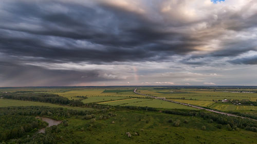 Scenic view of agricultural field against sky during sunset