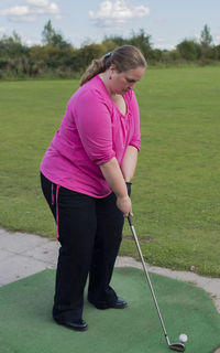 Full length of woman playing golf on field