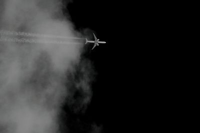 Low angle view of airplane flying against sky