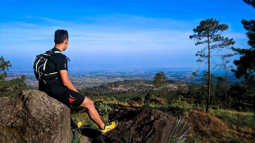 Man on rock against sky