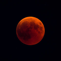 Orange moon against sky at night