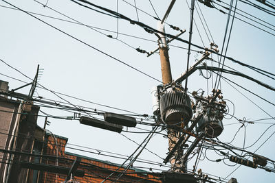 Low angle view of electricity pylon against sky
