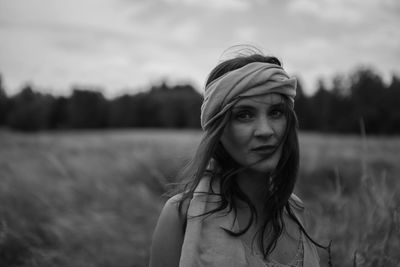 Portrait of woman wearing headscarf standing on field