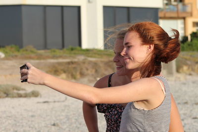 Portrait of smiling young women using mobile phone