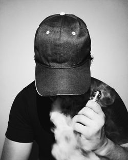 Close-up of man holding cigarette against white background