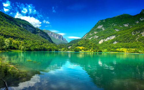 Scenic view of lake and mountains against blue sky