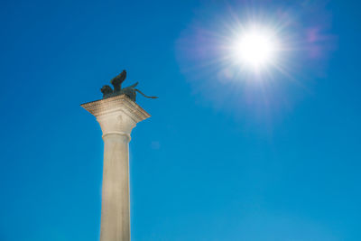Low angle view of bird against blue sky