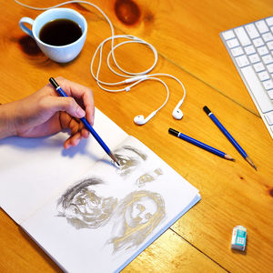 High angle view of hand drawing on paper on table