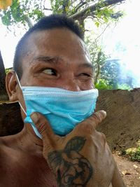 Portrait of mid adult man holding tree