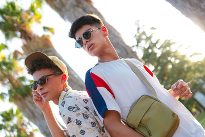 Portrait of smiling friends standing against trees