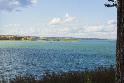 View of calm lake against cloudy sky