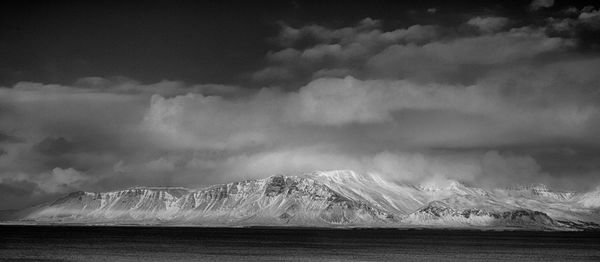 Scenic view of sea and mountains against sky