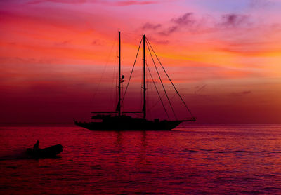 Ship sailing in sea against sky during sunset