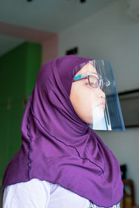 Girl in hijab wearing face mask at home