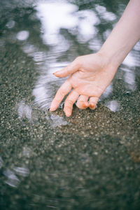 Close-up of hand touching water