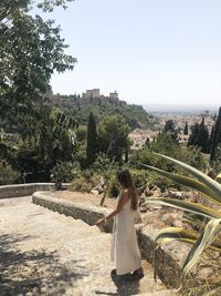 Rear view of woman standing against the alhambra and with clear sky