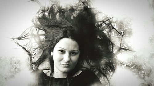 Portrait of a young woman against trees