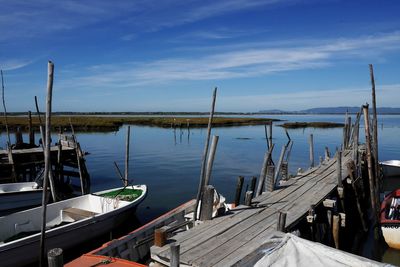 Wooden pier in lake against sky