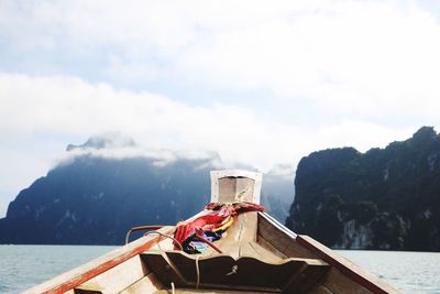 Boat sailing on mountain against sky