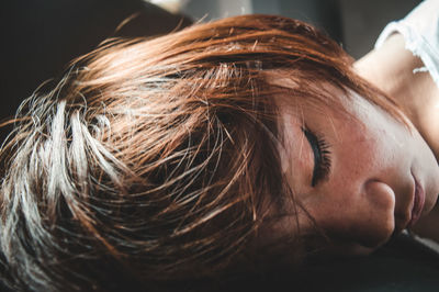 Close-up of tired woman sleeping on table