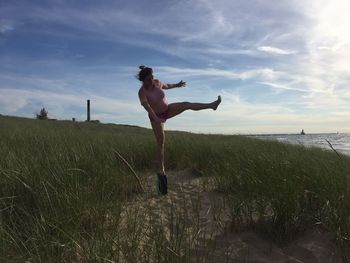 Full length of young woman jumping on beach