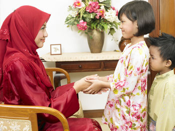 Mother and daughter holding hands at home