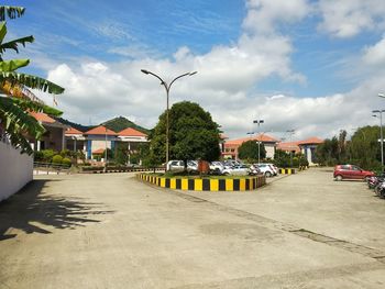 Street amidst houses and buildings in city against sky