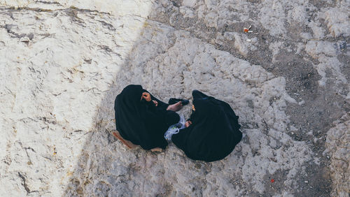 High angle view of women wearing hijab while sitting on field