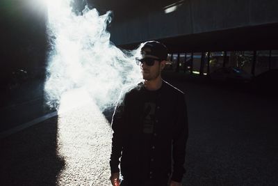 Young man smoking cigarette on street