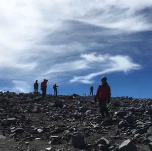 Hikers on mountain against sky