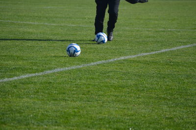 Low section of person playing soccer on field