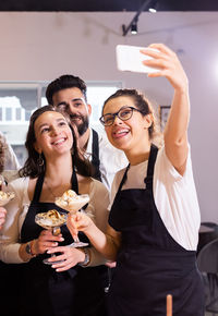 Portrait of smiling friends standing against wall