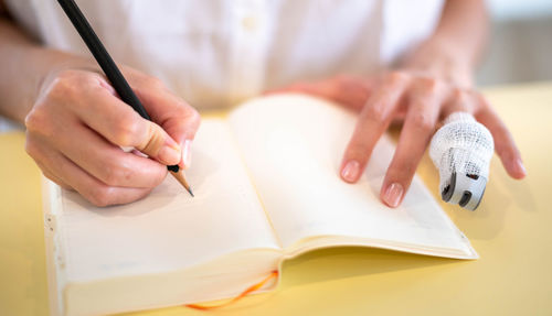 Midsection of woman drawing on paper