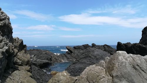 Rocks on beach against sky