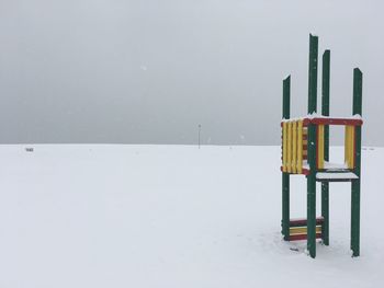 Wooden posts on snow covered field