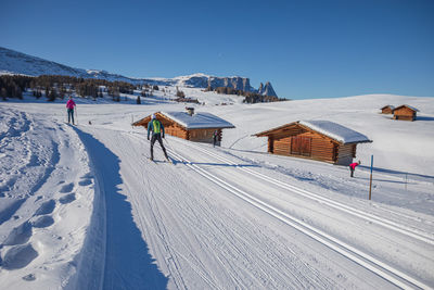 People skiing on snow covered landscape